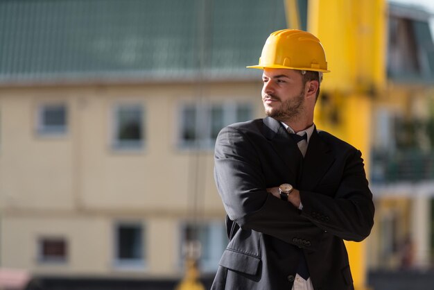 Retrato de hombre de negocios con casco amarillo en construcción