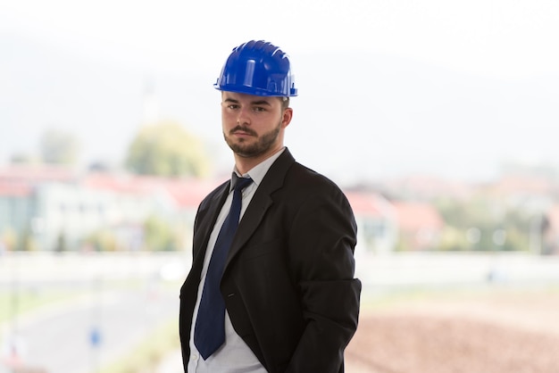 Retrato de hombre de negocios con casco azul en construcción