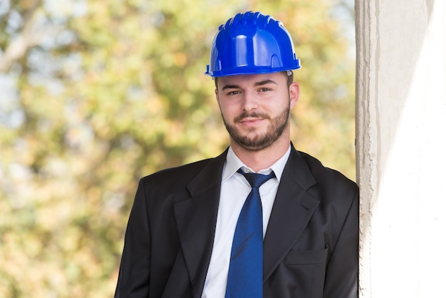 Retrato de hombre de negocios con casco azul en construcción