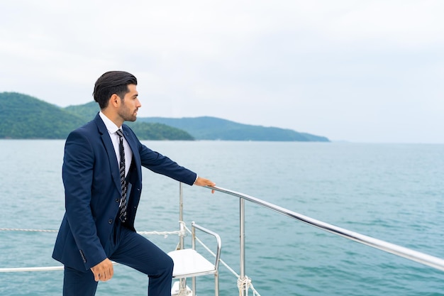 Retrato hombre de negocios caucásico confiado relajarse y disfrutar de un estilo de vida al aire libre de lujo para viajes de negocios exitosos en un lujoso catamarán privado yate navegando en el océano en vacaciones de verano