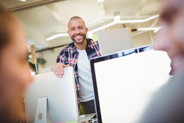 Retrato de hombre de negocios con colegas en la oficina