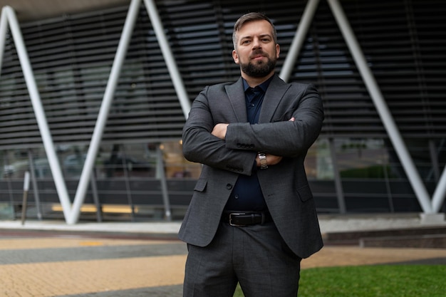 retrato de un hombre de negocios europeo confiado en un traje en el fondo de un edificio