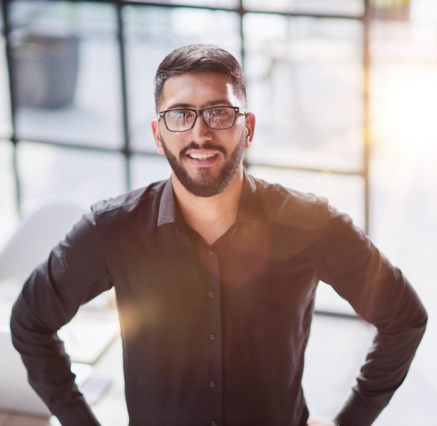 Retrato de hombre de negocios feliz confiado joven empresario de pie sonriendo mirando a la cámara