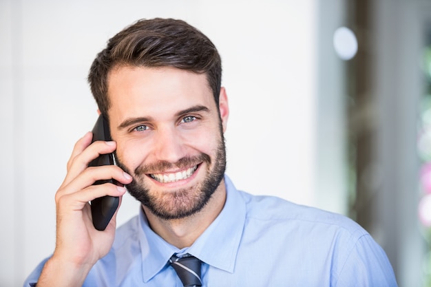 Retrato de hombre de negocios feliz hablando por teléfono móvil