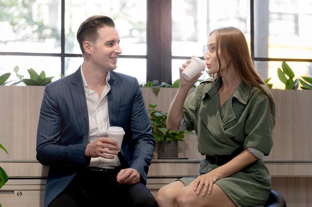 Retrato de hombre de negocios feliz y mujer sostienen una taza de café en el mostrador de café con biofilia natural para la vida de bienestar