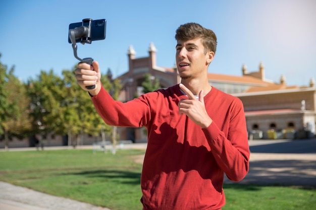 Retrato de un hombre de negocios grabando una presentación de video en un teléfono inteligente con cámara estable. Joven enfocado