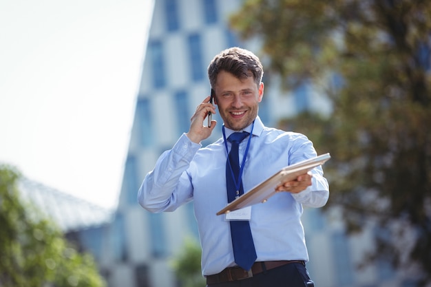 Retrato de hombre de negocios guapo hablando por teléfono móvil