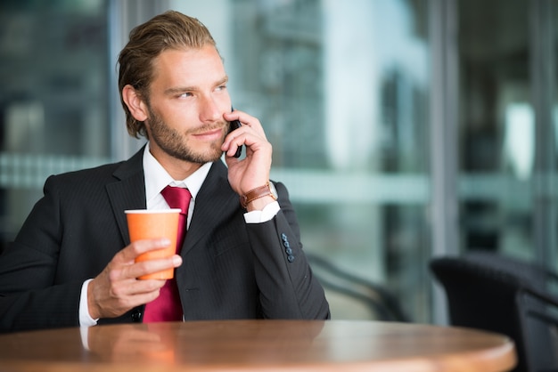 Retrato de un hombre de negocios guapo haciendo una llamada telefónica