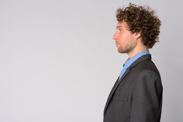 Retrato de hombre de negocios guapo con pelo rizado en blanco