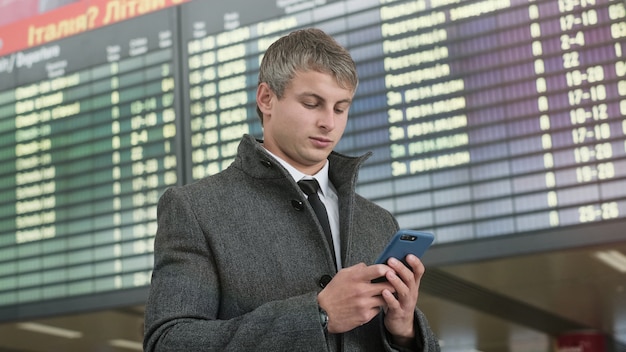 Retrato de hombre de negocios guapo con smartphone.