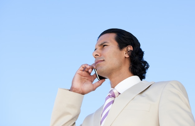 Retrato de un hombre de negocios guapo usando un teléfono celular