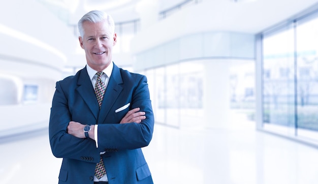 Retrato del hombre de negocios mayor delante de su oficina moderna