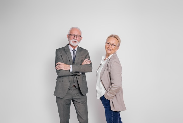 Retrato de un hombre de negocios y una mujer de negocios confiados sonriendo y posando sobre un fondo blanco