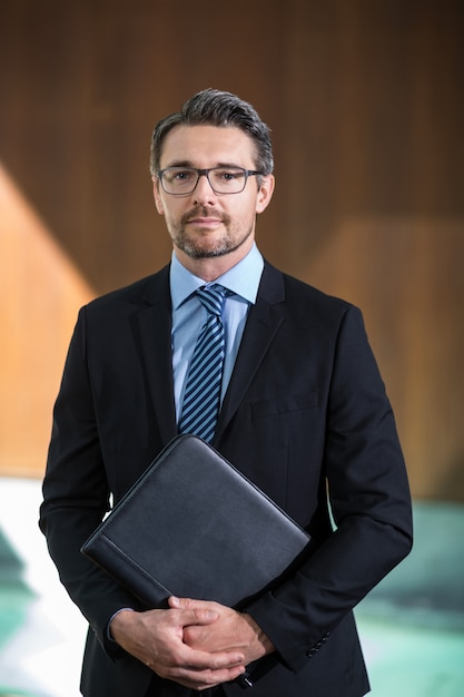 Retrato de hombre de negocios de pie en el resort