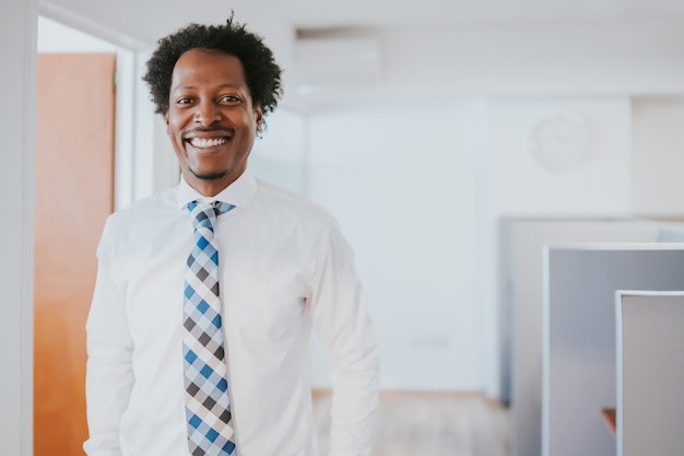 Retrato de hombre de negocios profesional sonriendo mientras está de pie en la oficina moderna. Concepto de negocio y éxito.