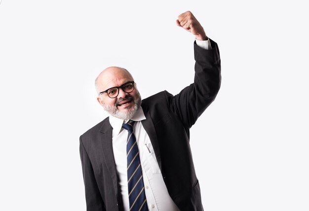 Retrato de un hombre de negocios senior indio asiático disfrutando o celebrando el éxito gritando o con el símbolo de los pulgares arriba contra un blanco aislado