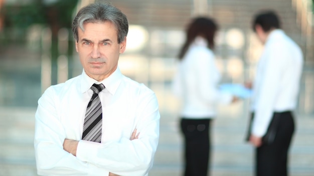 Retrato de un hombre de negocios senior en la oficina de fondo borroso.Foto con espacio de copia