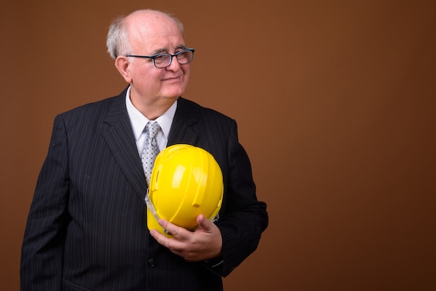 Retrato de hombre de negocios senior con sobrepeso con casco