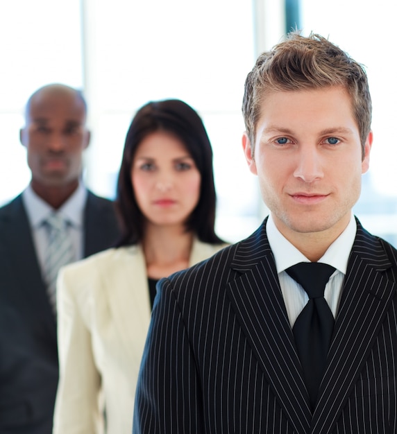 Retrato de un hombre de negocios serio frente a su equipo