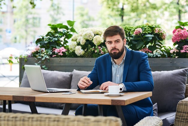 Retrato de hombre de negocios serio trabajando en café