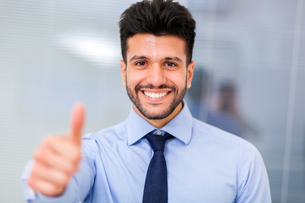 Retrato de un hombre de negocios sonriente dando pulgares