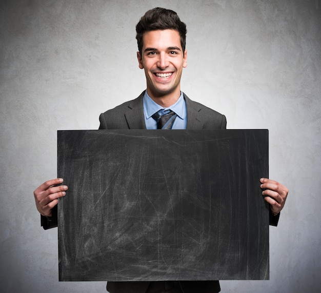 Retrato de un hombre de negocios sonriente sosteniendo una pizarra