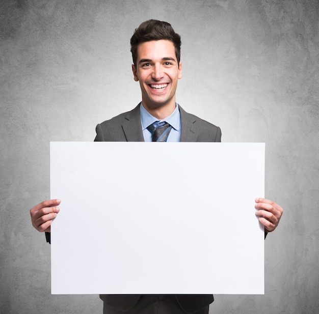 Retrato de un hombre de negocios sonriente sosteniendo un tablero blanco