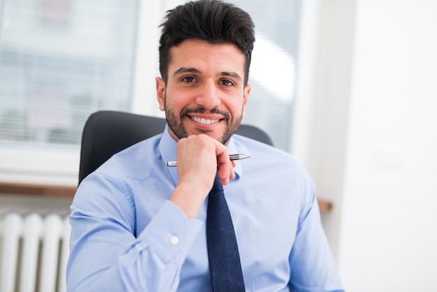 Retrato de un hombre de negocios sonriente en su oficina