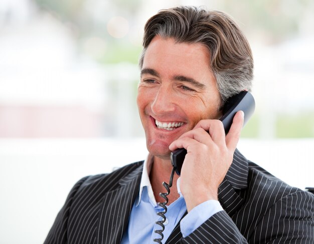 Retrato de un hombre de negocios sonriente en el teléfono