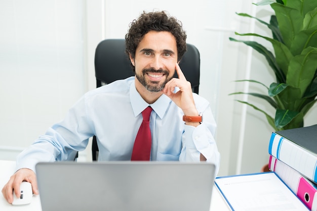 Retrato de un hombre de negocios sonriente en el trabajo en su oficina