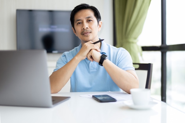 Retrato de hombre de negocios trabajando en equipo portátil en la oficina.