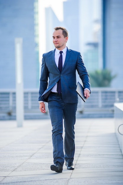 Retrato de hombre de negocios yang en traje al aire libre. Hombre caminando.