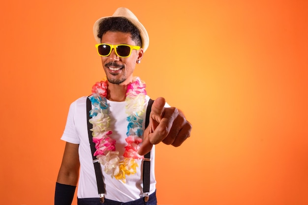 Foto retrato, de, hombre negro, con, carnaval, props, aislado, en, naranja, plano de fondo