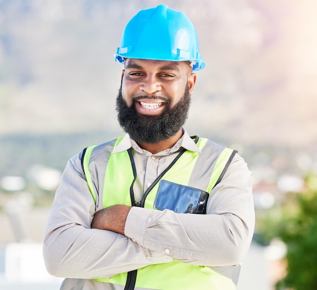 Retrato de hombre negro feliz y arquitecto con los brazos cruzados en la ciudad para la gestión de la construcción en el sitio Cara de persona masculina africana ingeniero o contratista sonrisa para la arquitectura industrial en el techo