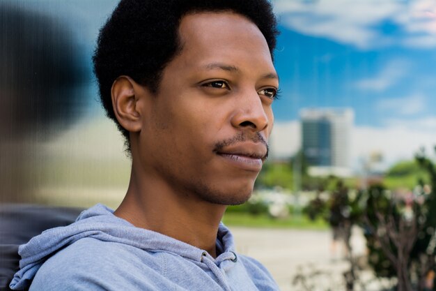 Retrato de hombre negro en el fondo urbano.