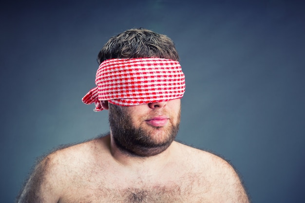 Foto retrato del hombre con los ojos vendados, aislado en gris