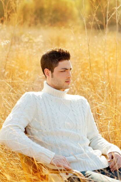 Retrato de hombre de otoño invierno en hierba seca al aire libre