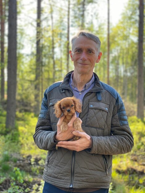 Foto retrato de un hombre con un perro en el bosque