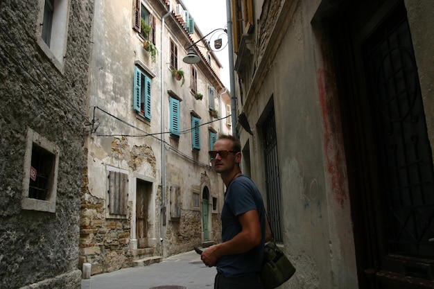 Foto retrato de un hombre de pie en un callejón entre edificios