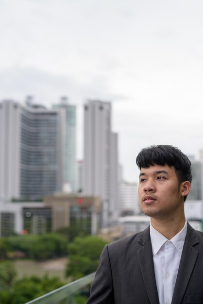 Retrato de un hombre de pie en la ciudad contra el cielo