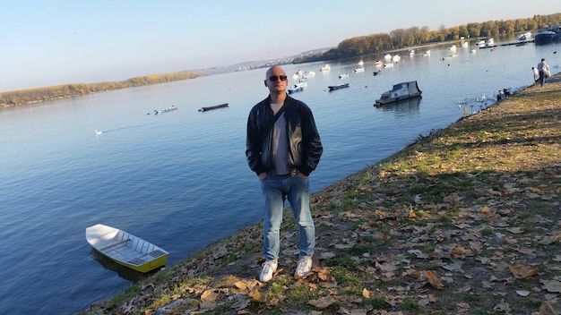 Foto retrato de un hombre de pie junto al lago contra el cielo