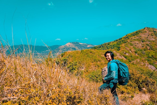 Foto retrato de un hombre de pie en tierra contra las montañas