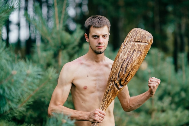 Retrato del hombre primitivo con pie de palo de madera en el bosque.