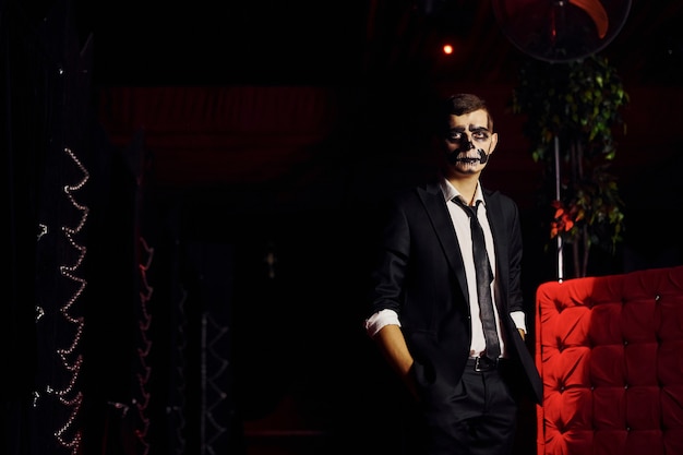 Foto retrato de hombre que está en la fiesta temática de halloween con disfraces y maquillaje de miedo.