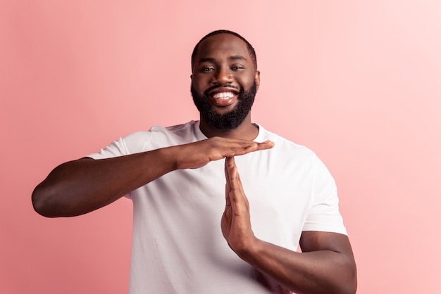 Retrato de hombre seguro mostrar signo de rotura sonrisa con dientes en la pared rosa