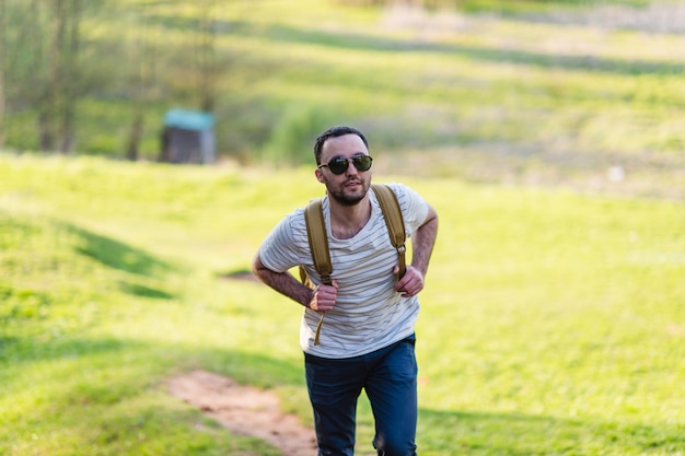 Retrato de hombre de senderismo con mochila caminando en la naturaleza