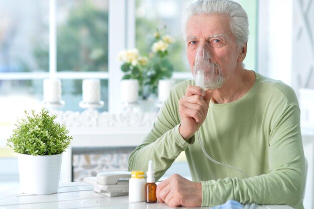 Retrato de hombre senior enfermo con inhalador