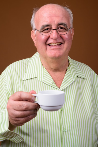 Retrato de hombre senior con sobrepeso sosteniendo la taza de café