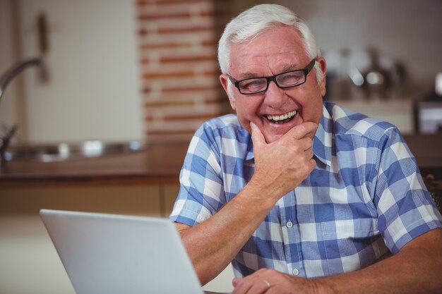 Retrato de hombre senior sonriente con laptop