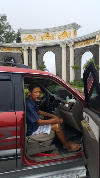 Foto retrato de un hombre sentado en un coche